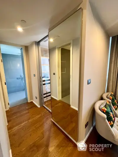 Modern hallway with wooden flooring and mirrored closet doors in a stylish apartment