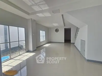Spacious modern living room with large windows and sleek tile flooring