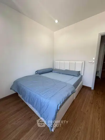 Cozy bedroom with modern decor and wooden flooring, perfect for relaxation.