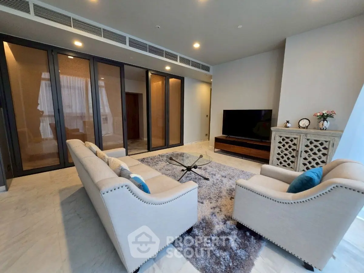 Luxurious living room with elegant furniture and large TV, perfect for relaxation.