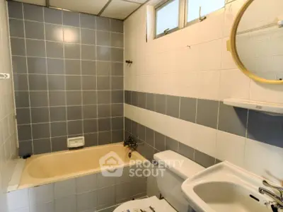 Charming bathroom with bathtub and modern tile design, perfect for relaxation.
