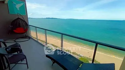 Stunning beachfront balcony with panoramic ocean views and cozy seating area.