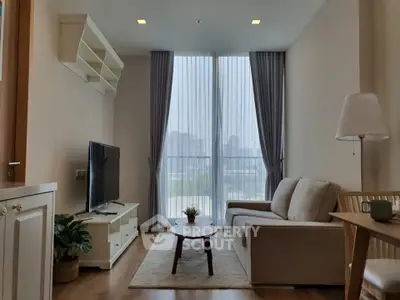 Cozy living room with large window and modern furniture, perfect for relaxation.