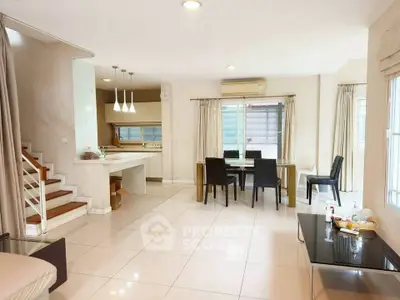 Spacious open-plan living and dining area with modern kitchen and staircase.