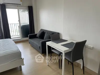 Modern studio apartment with cozy living area and balcony view