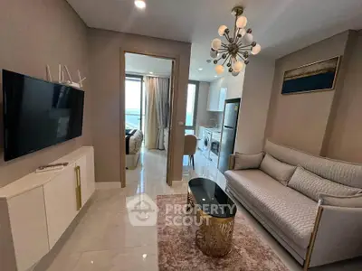 Modern living room with elegant decor, featuring a stylish sofa, chic chandelier, and a glimpse into a cozy bedroom.
