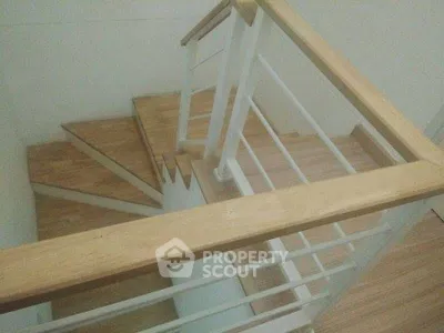 Modern wooden staircase with sleek railing in a contemporary home interior.