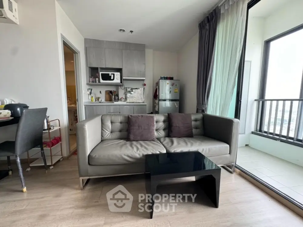 Modern living room with sleek sofa and compact kitchen in open layout apartment