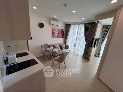 Chic modern living room with open kitchen, stylish decor, and abundant natural light.