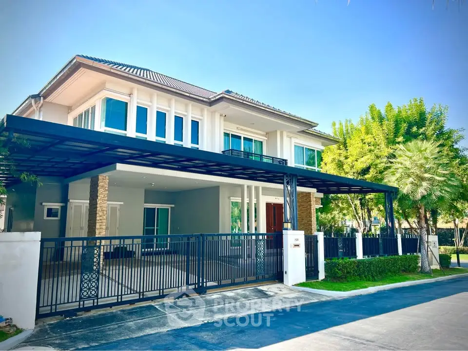 Stunning modern two-story house with spacious driveway and lush greenery, perfect for luxurious living.