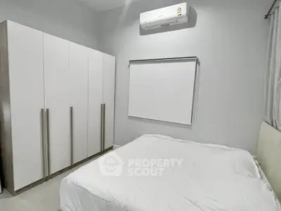 Modern minimalist bedroom with sleek wardrobe and air conditioning
