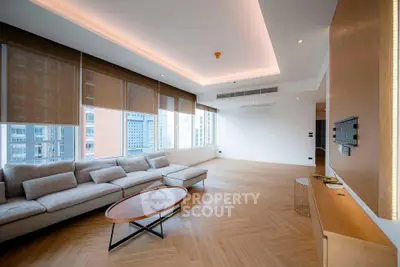 Spacious modern living room with large windows and elegant wooden flooring in a high-rise apartment.