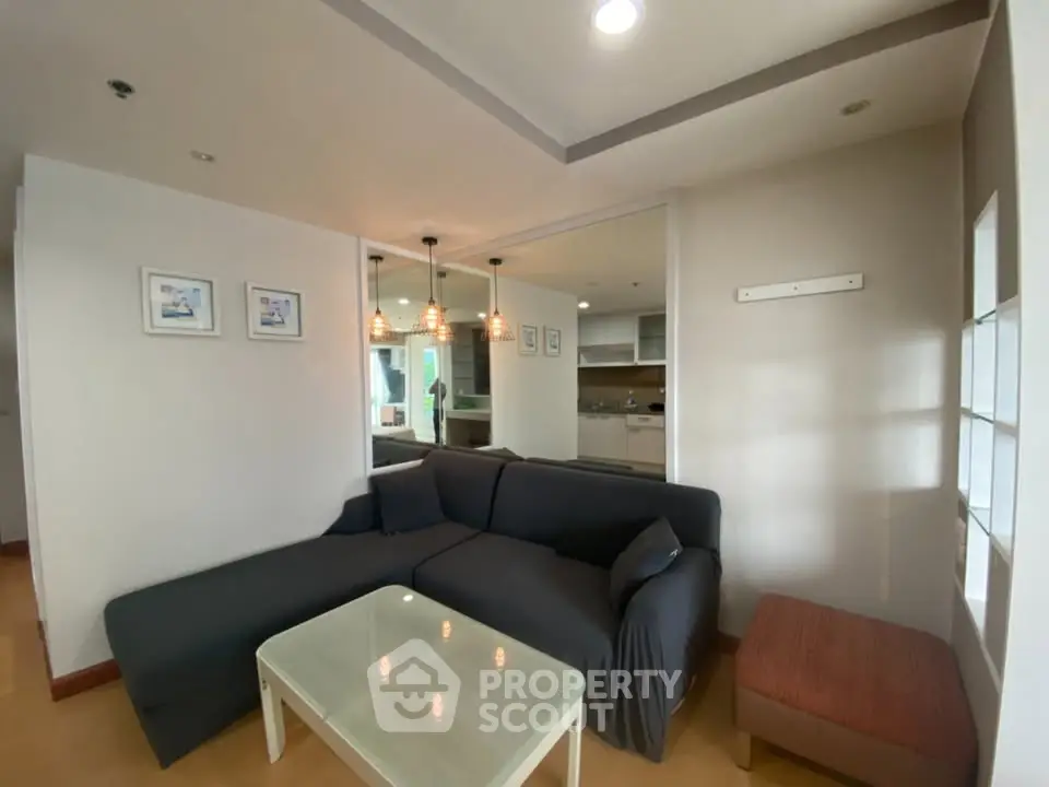 Modern living room with cozy sofa and stylish lighting in open layout apartment.