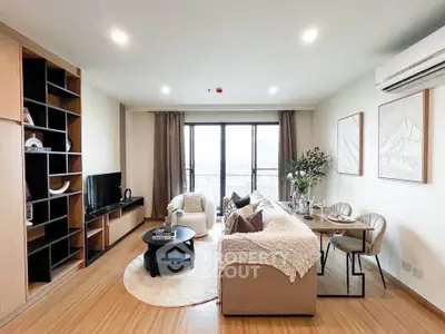 Modern living room with stylish decor, large window, and cozy seating area in a contemporary apartment.