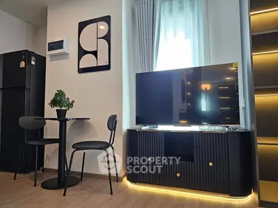 Modern living room with stylish decor, featuring a sleek TV stand, dining set, and ambient lighting.