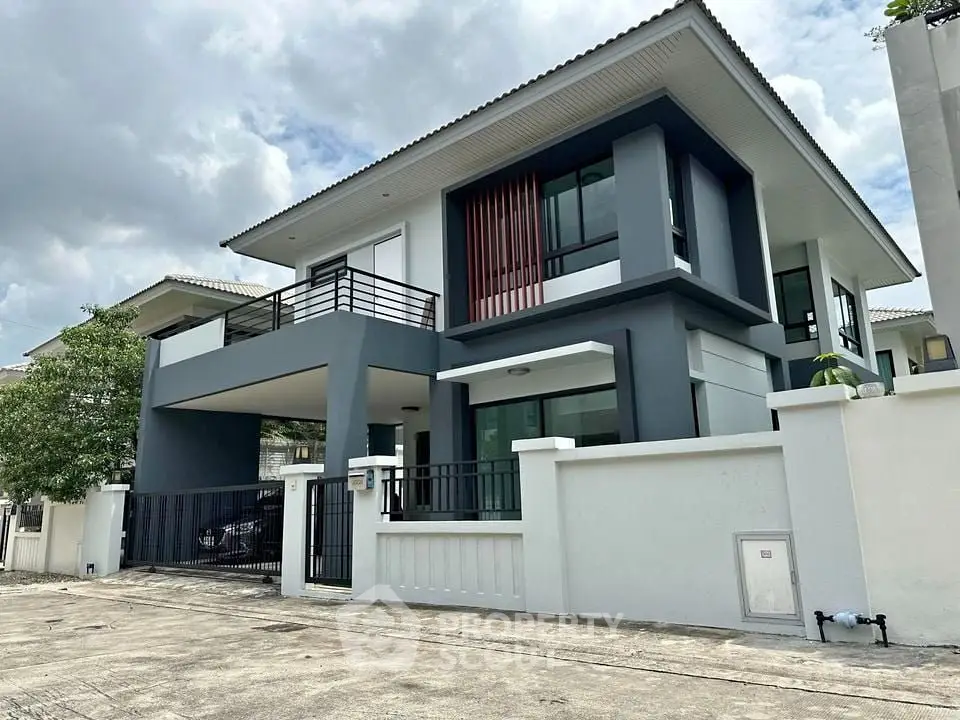 Modern two-story house with sleek design and spacious balcony in suburban neighborhood.