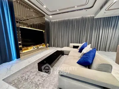 Luxurious modern living room with plush sofa and large TV, perfect for relaxation.
