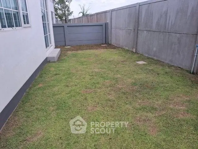 Spacious backyard with privacy fence and lush green lawn