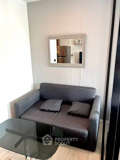 Cozy living room with modern gray sofa and glass coffee table, perfect for relaxation.