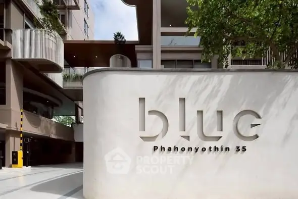 Modern building entrance with stylish signage at Blue Phahonyothin 35, showcasing contemporary architecture.