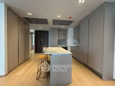 Modern kitchen with sleek cabinetry and island seating in a contemporary apartment.