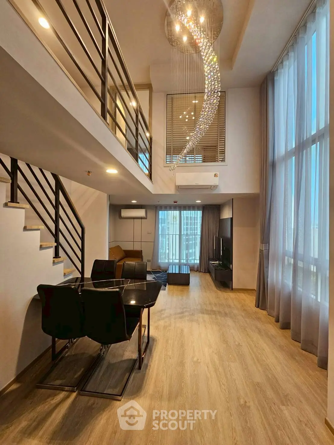 Luxurious duplex living room with high ceilings and modern chandelier