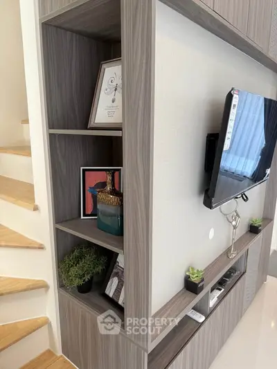 Modern living room with stylish shelving and mounted TV, perfect for contemporary living.
