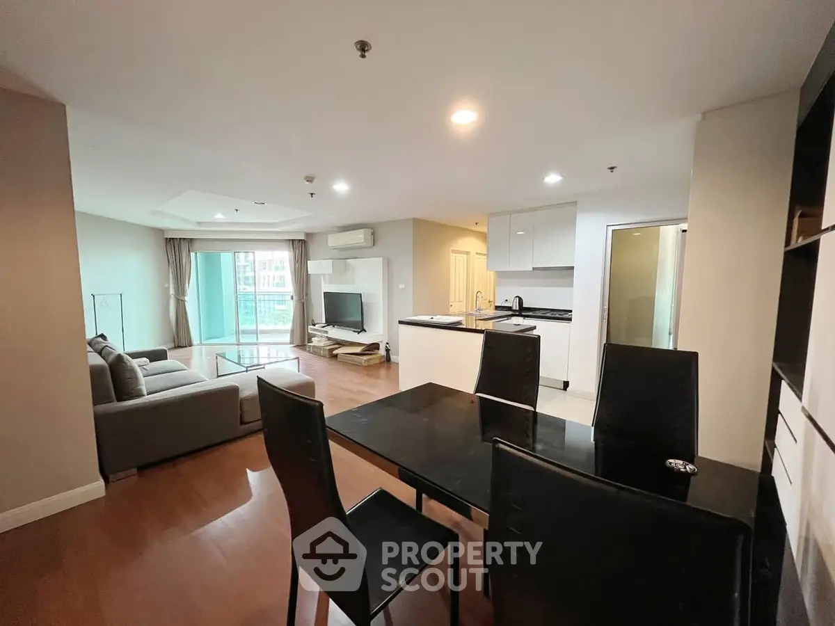 Spacious open-plan living room with modern kitchen and balcony view