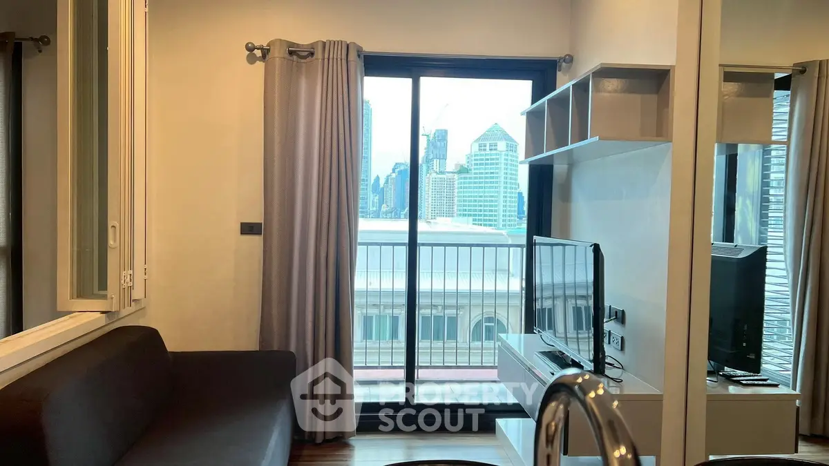 Modern living room with city view, featuring sleek furniture and large windows.