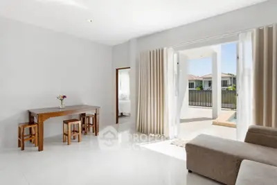Spacious living room with modern decor and pool view, perfect for relaxation and entertaining.