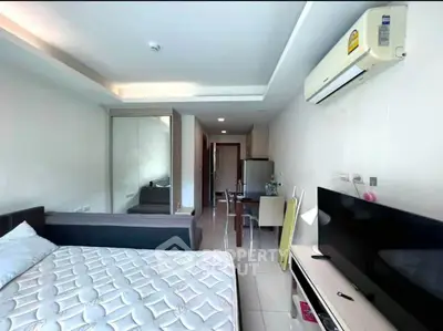 Modern studio apartment with sleek design, featuring a cozy bed, wall-mounted TV, and dining area.
