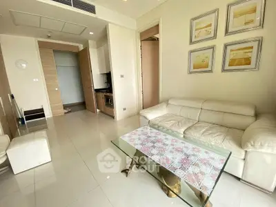 Modern living room with white leather sofa and glass coffee table in a stylish apartment.