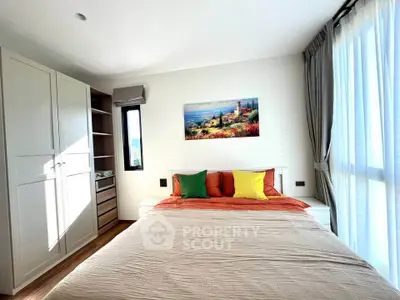 Bright and cozy bedroom with colorful pillows and large window