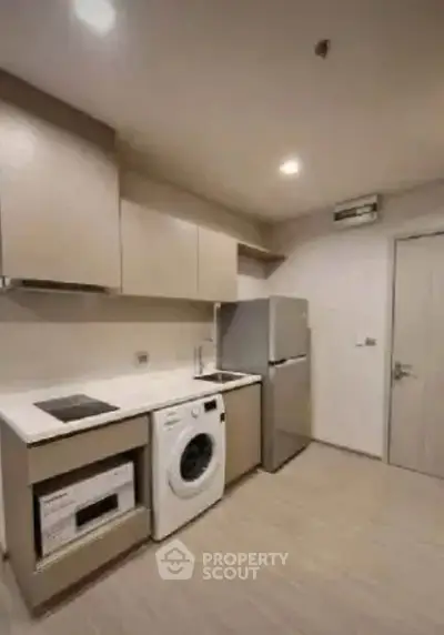 Modern kitchen with sleek appliances and ample storage in a contemporary apartment.