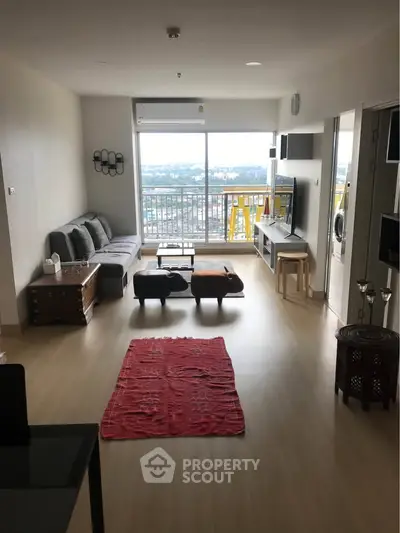 Spacious living room with modern furniture and large window offering stunning city views.