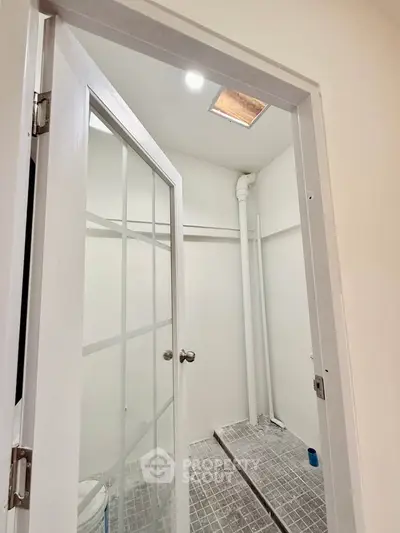 Minimalist bathroom with glass door and tiled floor