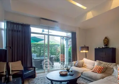 Spacious living room with cozy seating and garden view, perfect for relaxation and entertaining.