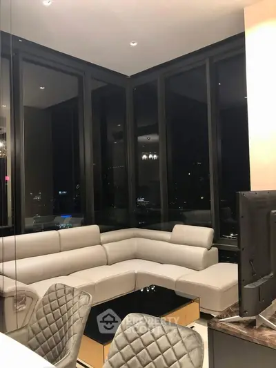 Luxurious modern living room with panoramic city views and elegant furnishings.
