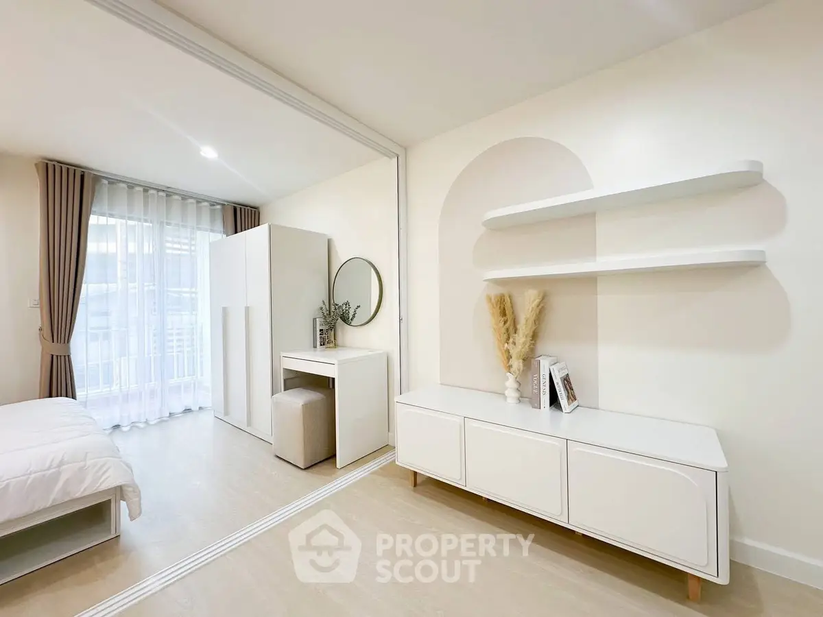 Modern bedroom with minimalist decor, featuring a cozy bed, stylish shelves, and a bright window view.