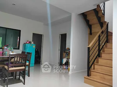 Spacious living area with gleaming tiled floors and an elegant wooden staircase leading to the upper level, perfect for family gatherings.