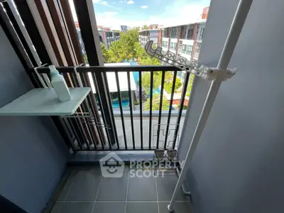 Charming balcony with pool view in modern apartment complex, perfect for relaxation and enjoying the scenery.