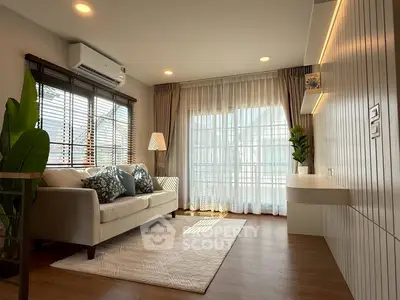 Chic modern living room with cozy sofa, elegant lighting, and large windows for natural light.