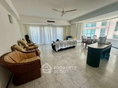Spacious living room with elegant furniture and large windows offering natural light in a modern apartment.