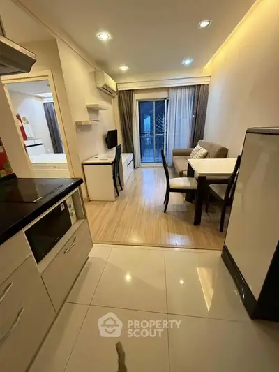 Modern open-plan living room with kitchen and balcony access