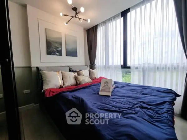 Modern bedroom with large windows and stylish decor, offering a serene and inviting atmosphere.