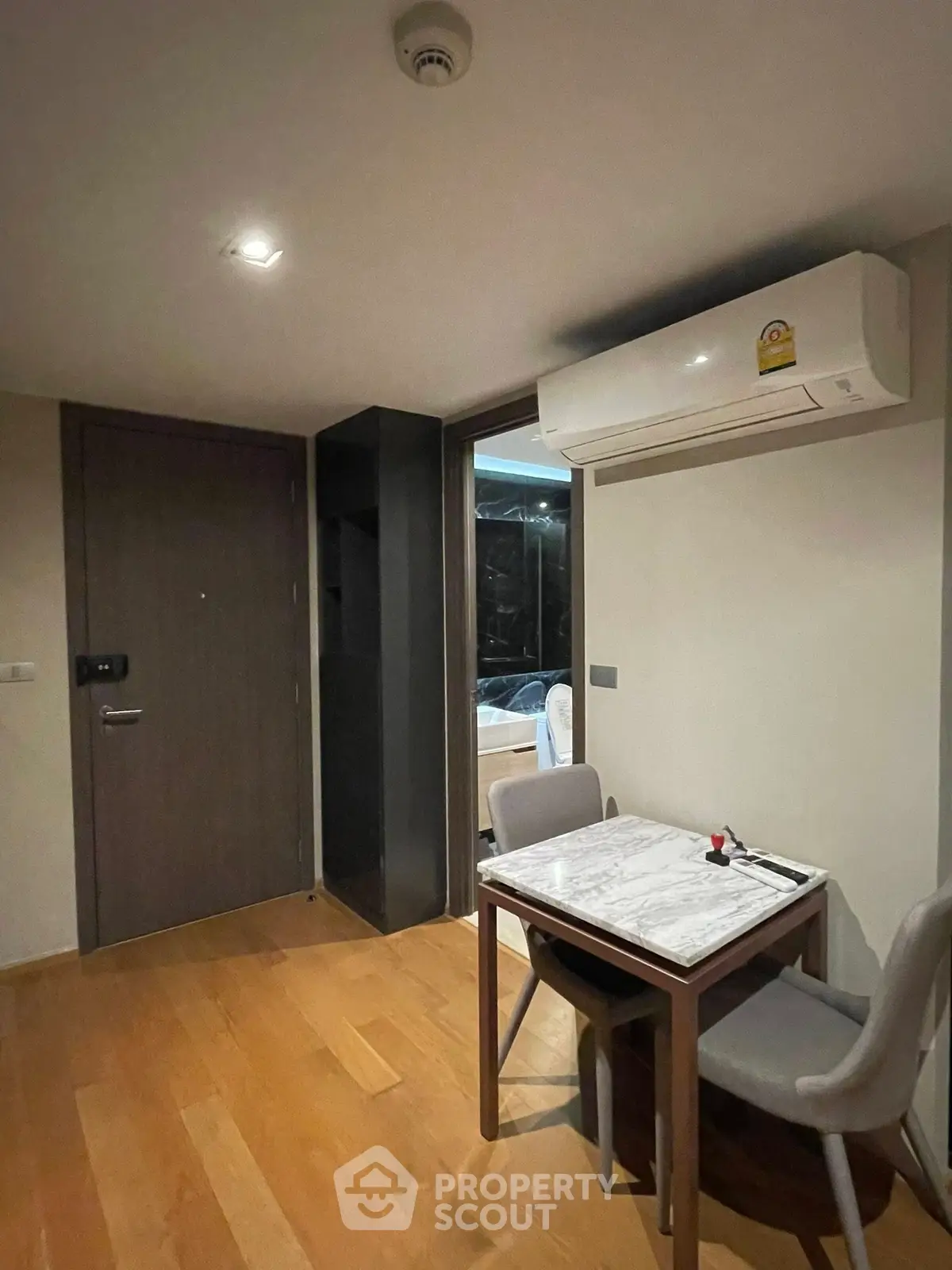 Cozy dining area with marble table and air conditioning in modern apartment
