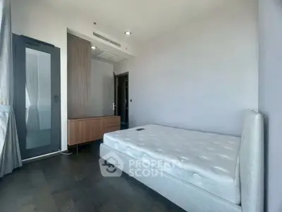 Spacious bedroom with modern design and large window offering natural light.