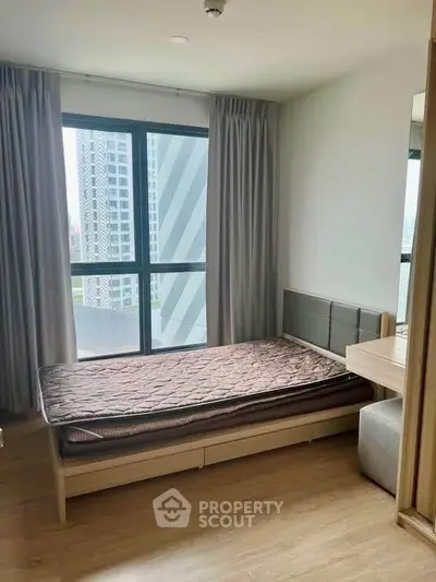 Modern bedroom with large window and city view in high-rise apartment