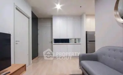 Modern living room with sleek furniture and open kitchen layout in a stylish apartment.