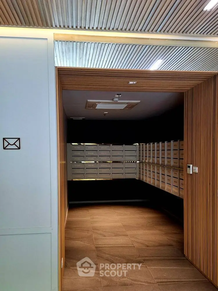 Modern apartment mailroom with sleek wooden design and ample mailboxes.